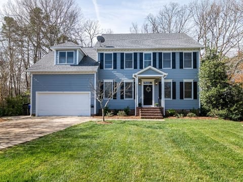 Blue two-story house with a front lawn