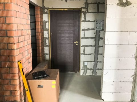 Bare interior during construction, with brick and concrete walls