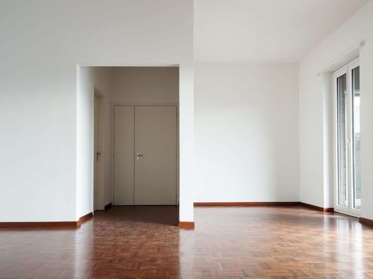 Empty room with a hardwood floor and white doors