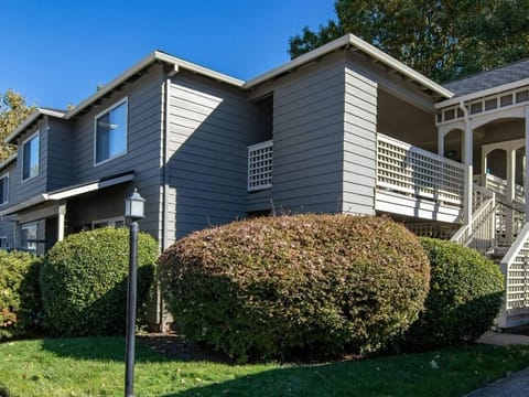Grey two-story house with a trimmed hedge out front