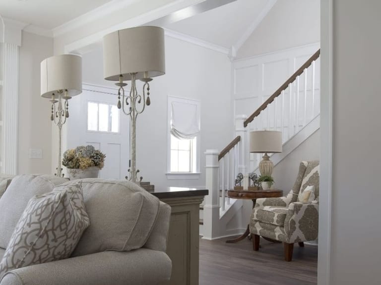 Living room with a sofa, an armchair and a staircase behind