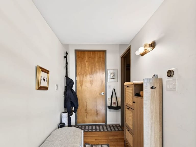 Entryway with a bench, coat hooks and a wooden front door